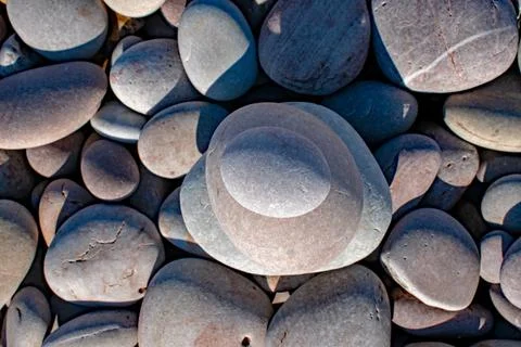 Unusual perspective of a stack of pebbles seen from above on a pebbly beach Stock Photos