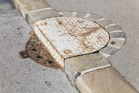 Unusual sewer hatch located on the road and the sidewalk in Slovenia Stock Photos