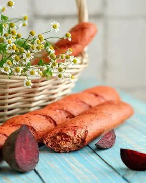 Unusual vegetable bread with beetroot. Broken loaf of bread on rustic table with Stock Photos