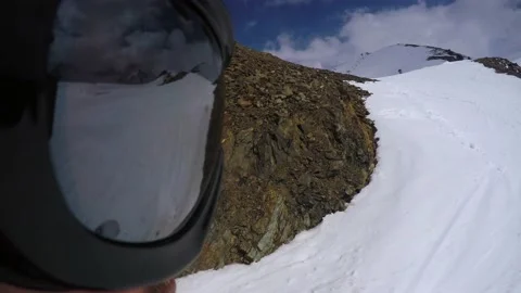 Unusual view from action camera aimed at mask of snowboarder going down slope Stock Footage 138692414