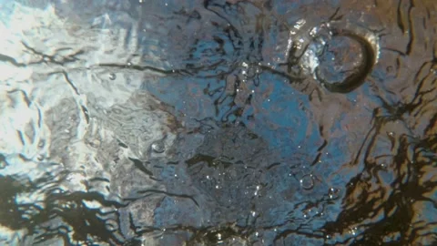 An unusual view from under the water on the surface of a fast river on which Video stock 149440343