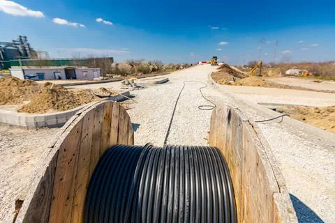 Unwinding cable of spool, coil at construction site Stock Photos