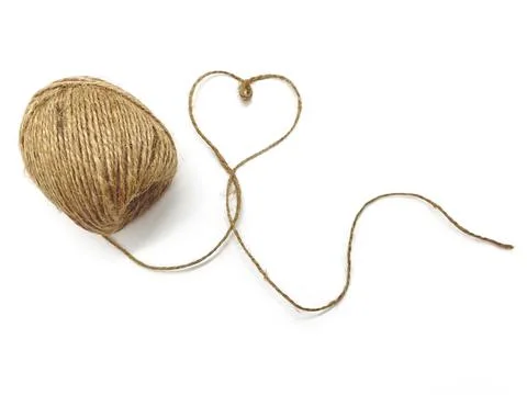 An unwound ball of thread, the thread forms a heart on a white background. Stock Photos