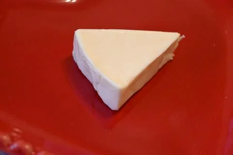 Unwrapped processed cheese on a red plate Stockfoto's