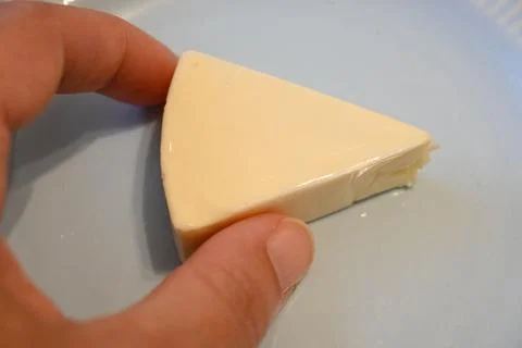 Unwrapped processed cheese wedge Photos