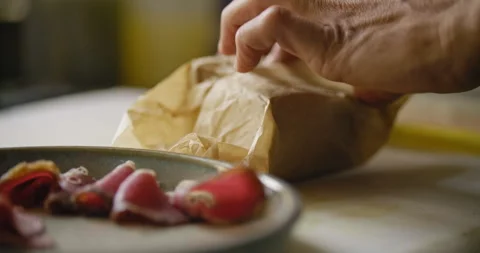 Unwrapping the block of brown ingredients the chef prepares to add it to di.. Stock Footage 274654575