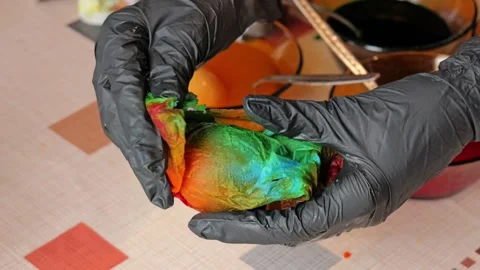 Unwrapping dyed Easter egg in home setting close up Stock Footage 332677971