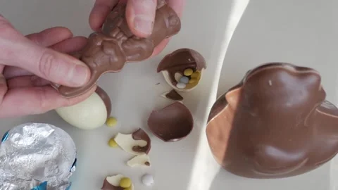 Unwrapping an Easter Chocolate Egg Filled with Candy Surprises Stock Footage 332943161