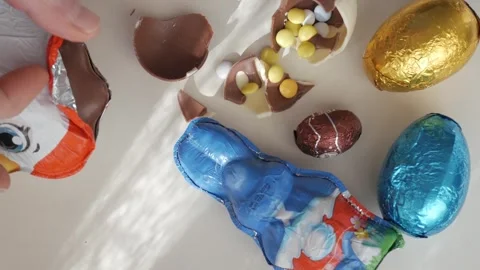 Unwrapping Easter Eggs to Reveal Delicious Chocolate and Candy Surprises Stock Footage 332943329