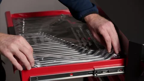 Unwrapping new hand tools in workshop tool cabinet Stock Footage 326042253