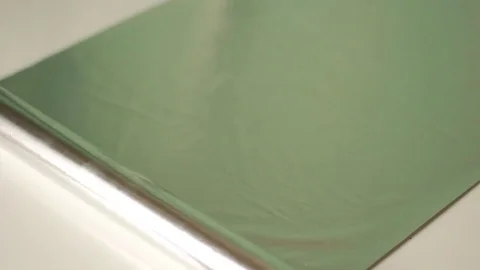 Unwrapping silver foil on a table 스톡 동영상 73505416