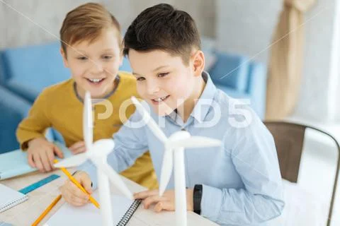 Upbeat boys drawing wind turbines at fathers workplace Stock Photos