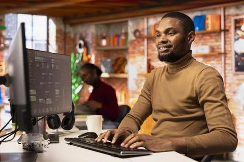 Upbeat IT engineer coding advanced AI algorithm in startup office 스톡 사진