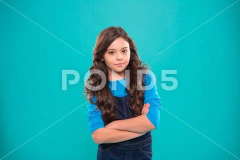 Upbringing confidence. Kid girl long hair posing confidently. Girl curly Stock Photos
