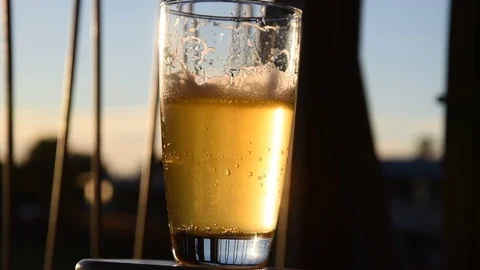 Upclose bubbling beer with sunset Stock Footage 77491817
