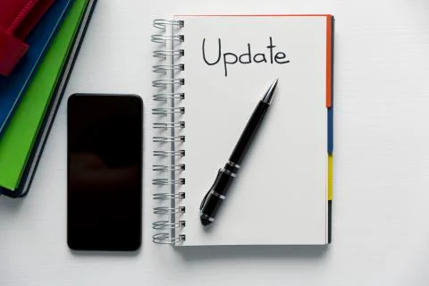 Update - handwritten text in a notebook on a desk. Project update checklist. Stock Photos