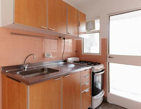 Updated retro kitchen with door and window to the outside in empty apartment Stock Photos
