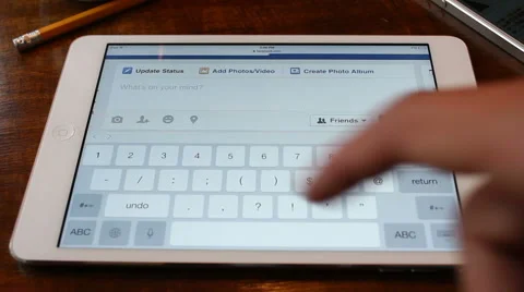 Updating Facebook Status on iPad Stock Footage 62052499