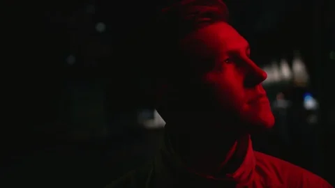 Upet young man looking around on the dark street at night near the red neon sigh Vidéo 108123708