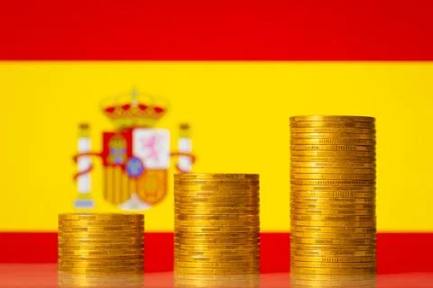 Upgoing graph made of coins stacked in front of Spain flag Stock Photos