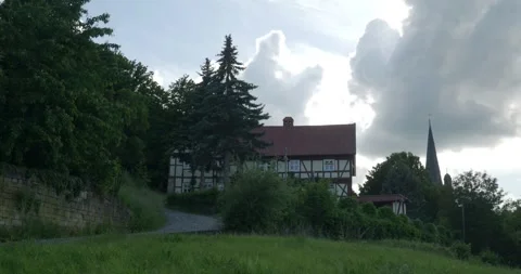 Uphill view panning with half-timbered house and church tower in Blankenburg GER Stock Footage 276351279