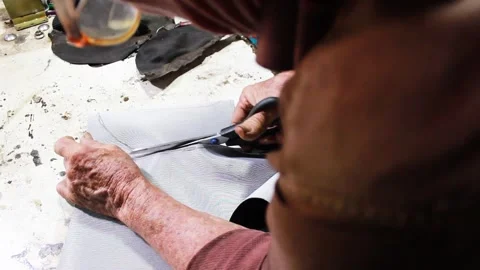 An upholsterer cutting a piece of leather with scissors Stock Footage 304713875