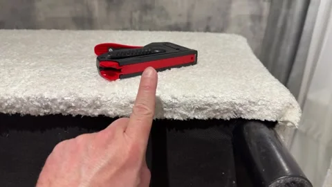 Upholsterer holding a mechanical stapler for upholstering furniture, insert.. Stock Footage 320226131