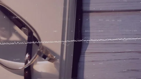 Upon audio playback waveform rising into peaks subsiding above glasses on book Stock Footage 310438088