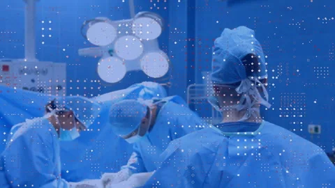 Upon camera focus shift surgeon adjusting mask fist pumping while team suturing Stock Footage 313618205