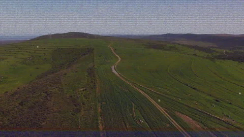 Upon liftoff drone flying forward over winding dirt path to reveal patchwork Stock Footage 310864544