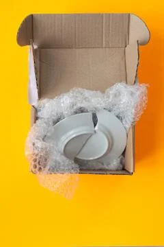 Upon opening, the parcel contained a broken plate, yellow background Foto stock