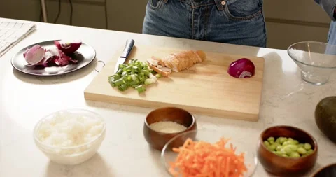 Upon prep start cooks are slicing tomato wedges chopping scallions at island Stock Footage 337624306