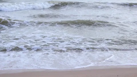 Upon the sandy shore, waves crash and retreat, symbols of flow, resilience Stock-Footage 334848705