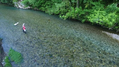 Upper backside view fisherman throws rod in shallow river Stock Footage 102332305