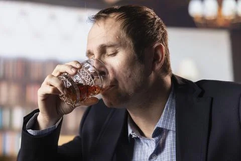 Upper class billionaire drinking whiskey at the elite social club gathering Stock Photos
