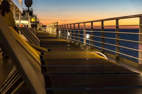 Upper deck of a cruise ship at sunset with sun loungers assembled Stock Photos