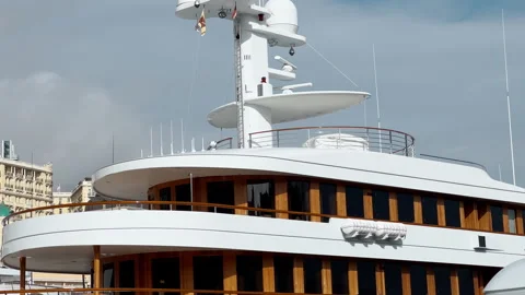 The upper decks of a huge white mega yacht at sunset, wooden window elements Stock Footage 260013350