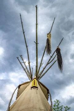 Upper end of a Native American tepee with poles, horse tail and yellow bead Stock Photos