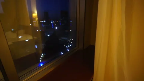 Upper floor hotel room window with night city view Stock Footage 105670810