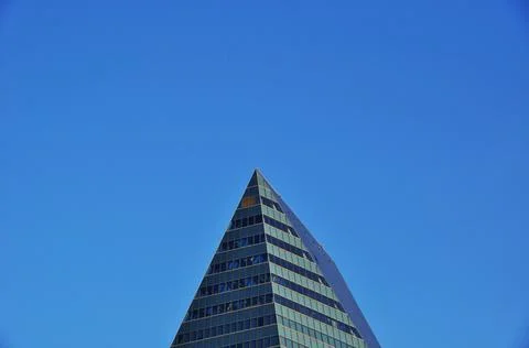 The upper floors of a skyscraper against a cloudless blue sky. Stock Photos