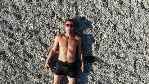 Upper motion from guy on pebble to general beach view Video stock 103182273