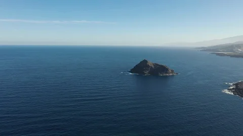 Upper motion to rocky island by beach against endless ocean Stock Footage 101962047