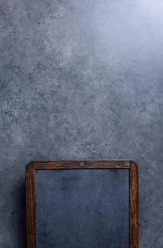 Upper part of aged chalk board over concrete desktop. Stock Photos