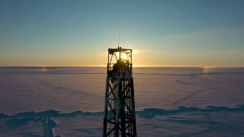 Upper part of drilling rig in rays of sun. Wheel of derrick crown block is Stock Footage 260261369