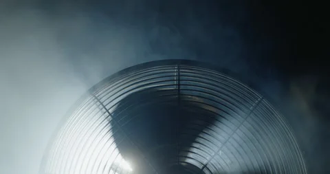 The upper part of a fan rotating in the smoke. The blades cover the spotlight Stock Footage 250527084