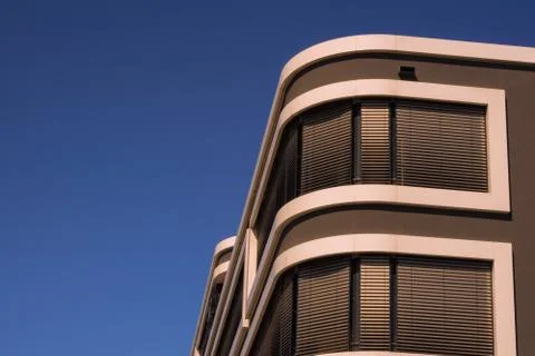 The upper part of a modern building below a blue sky Foto stock