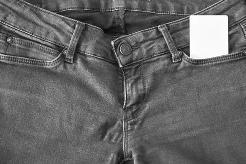 The upper part of old worn black jeans with pockets and a white tag for cloth Stock Photos