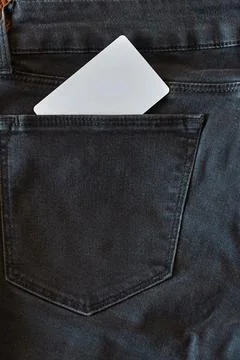 The upper part of old worn black jeans with pockets and a white tag for cloth Stock Photos
