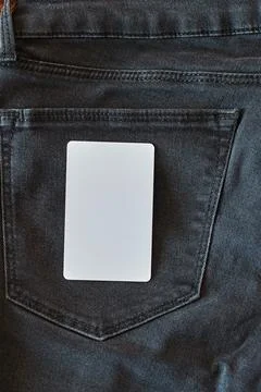 The upper part of old worn black jeans with pockets and a white tag for cloth Stock Photos