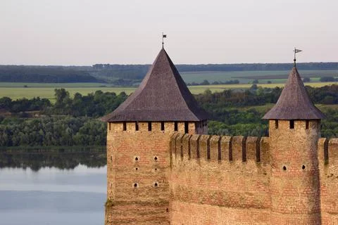 The upper part of the stone wall of a medieval fortress with battlements Stock Photos